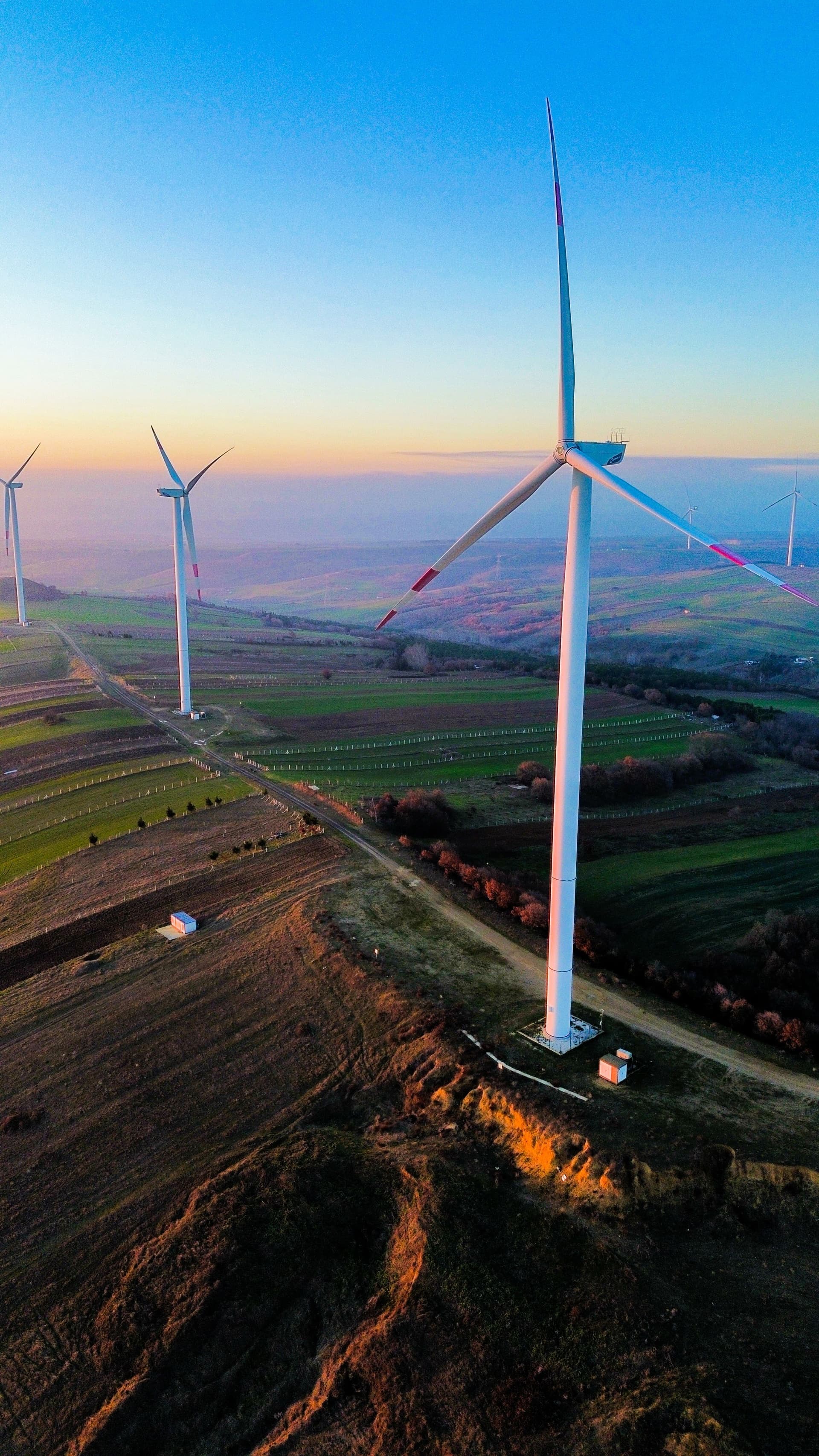 Wind turbines across rolling hills at golden hour