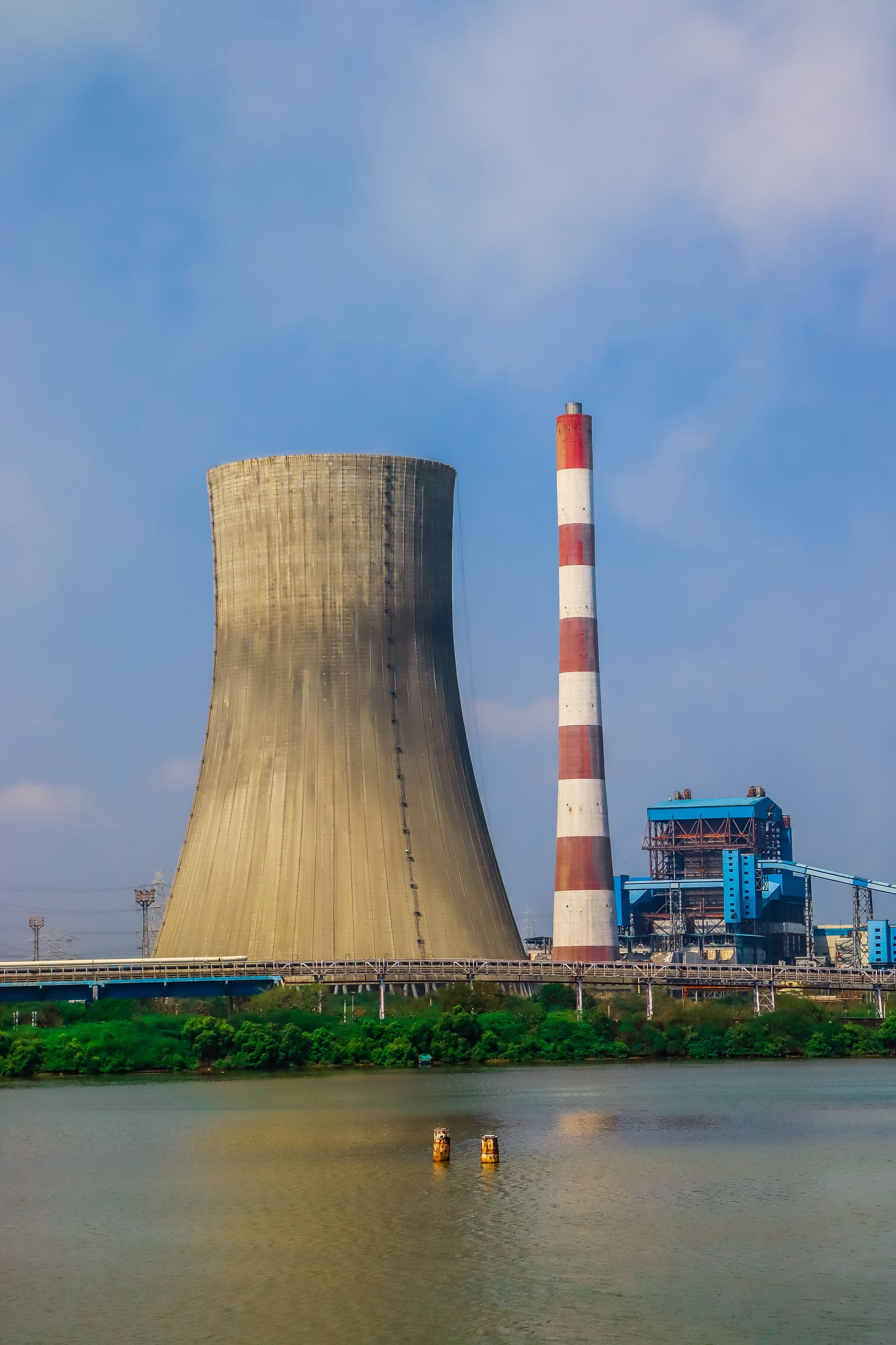 Power plant cooling tower and stack beside water
