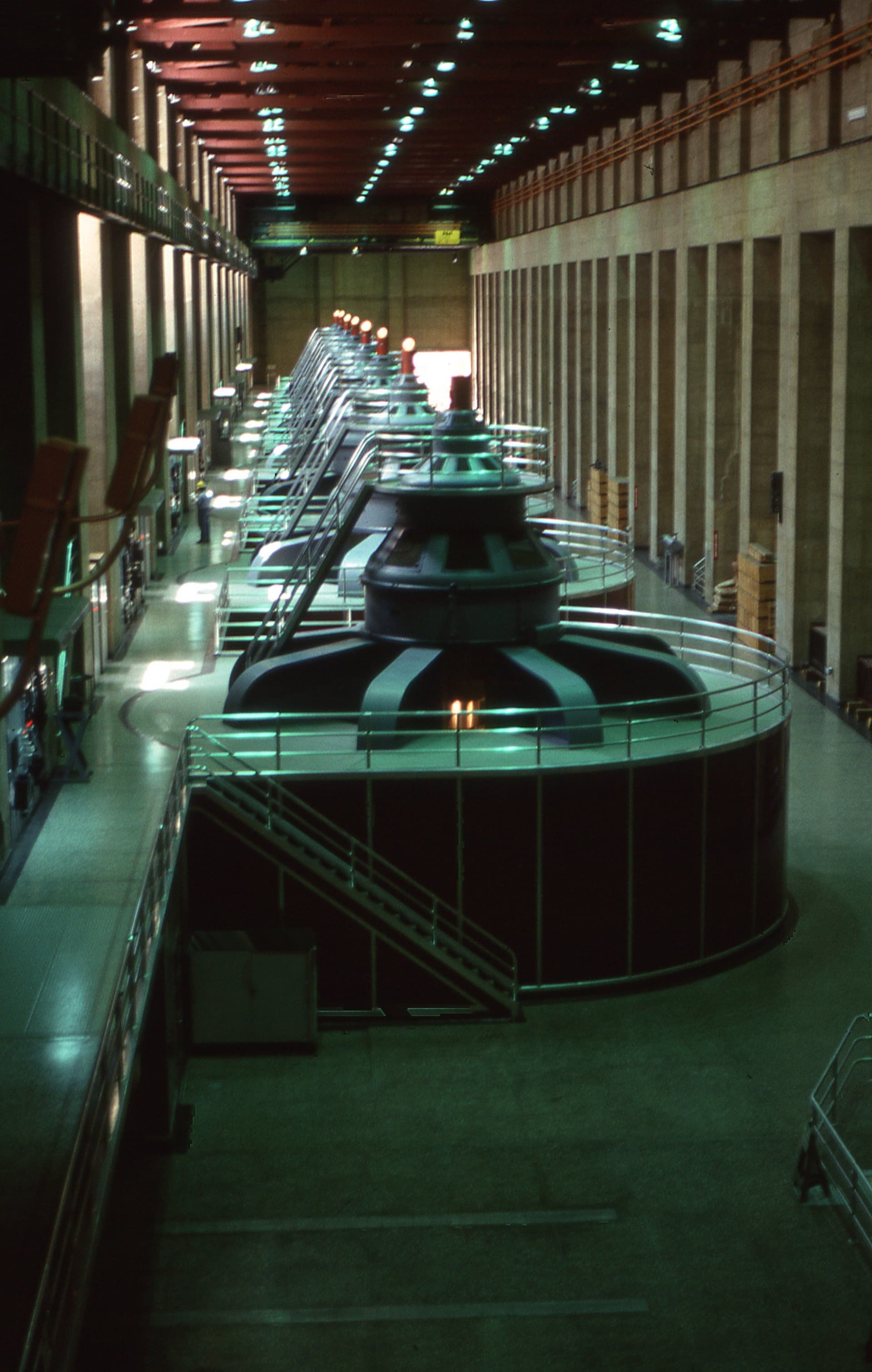 Row of large hydroelectric turbine generators inside a plant hall